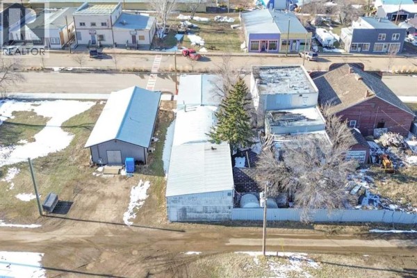 Aerial view of commercial buildings and backyards on Main Street, Donalda, with snow patches. - 5015 Main Street, Donalda
