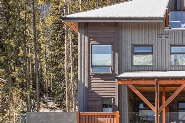 Close-up of townhouse corner showing wooden and stone materials, with windows - 501h, 3000 Stewart Creek Drive, Canmore