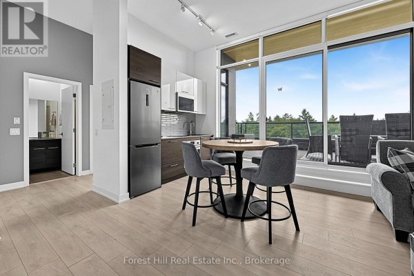 The open-concept kitchen and dining area connects to the living room and balcony. - 502 - 120 Carrick Trail, Gravenhurst)