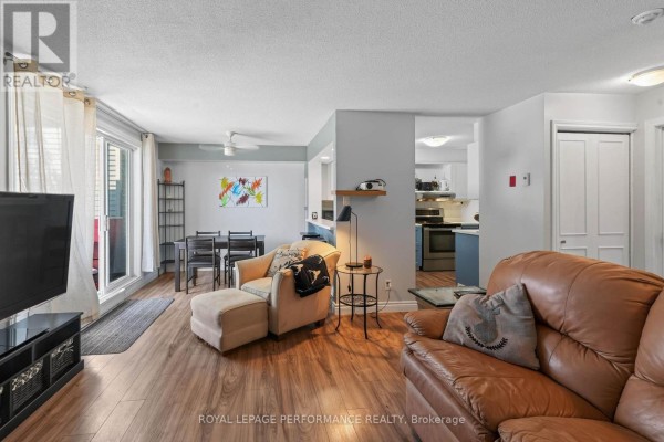 Open-concept living and dining area with a fireplace and kitchen view. - 502 - 1589 St Bernard Street, Ottawa
