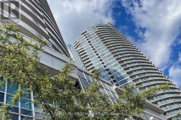 Exterior view of modern curved glass high-rise apartment buildings under a blue sky. - 502 - 218 Queens Quay W, Toronto