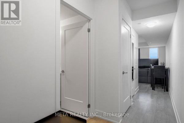 Interior hallway with white doors and trim, leading towards the living area. - 502 - 2550 Simcoe Street N, Oshawa