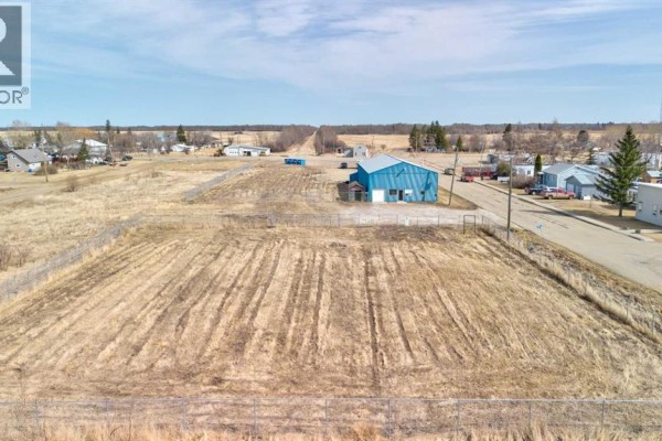 Front exterior of a blue metal commercial building with a small attached shed. - 5024 50 Avenue, Eaglesham