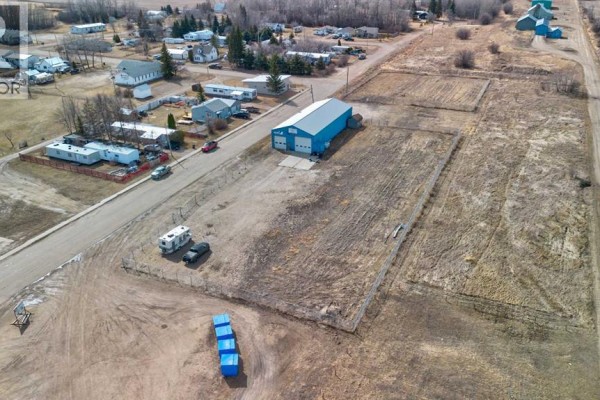 Side view of a blue metal clad commercial building with a metal roof and attached shed. - 5024 50 Avenue, Eaglesham