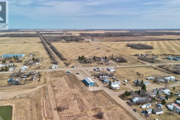 Top down view of the metal roof of a long, blue commercial building. - 5024 50 Avenue, Eaglesham