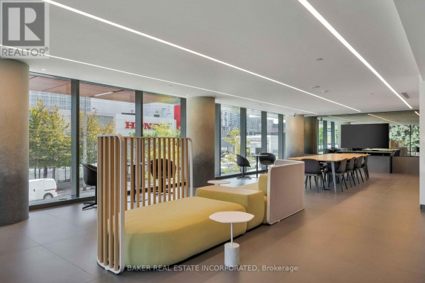 Contemporary seating area with modular sofa and additional tables in a bright communal space. - 503 - 28 Eastern Avenue, Toronto