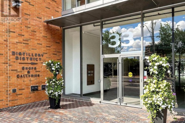 Glass entrance doors with '33' number and potted plants flanking. - 503 - 33 Mill Street, Toronto