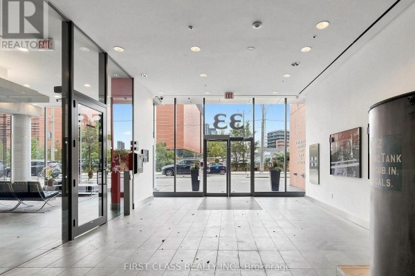 Building lobby with tiled floor, glass doors, and exterior view. - 503 - 33 Mill Street, Toronto