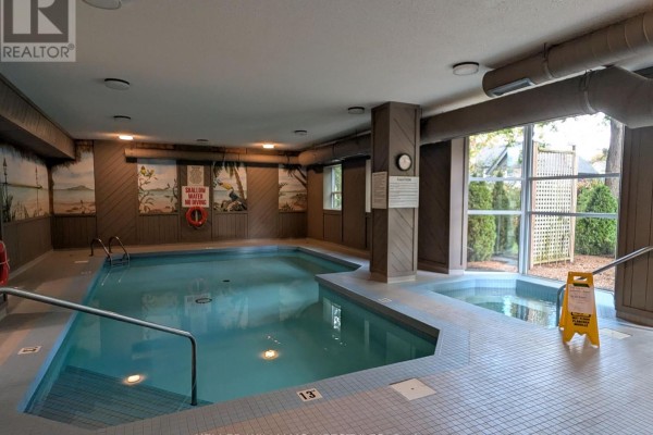 Indoor swimming pool with a separate hot tub area and wood-paneled walls. - 503 - 600 Talbot Street, London East