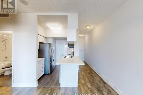 View of an open-concept apartment with a kitchen island and a glimpse of a bathroom. - 503 - 8 Hillcrest Avenue, Toronto