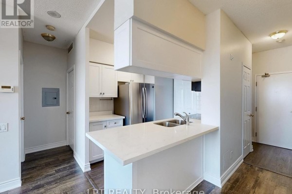 View of the apartment interior showing a kitchen island, cabinets, and a hallway. - 503 - 8 Hillcrest Avenue, Toronto