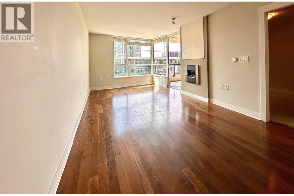 Bright living area with polished hardwood floors, large windows, and access to a balcony. - 503 160 W 3rd Street, North Vancouver