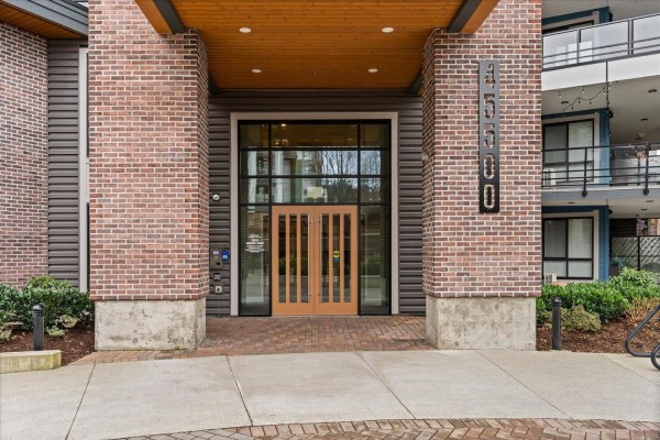 Corner view of the building highlighting balconies and landscaping - 503 45500 Market Way, Garrison Crossing, Chilliwack