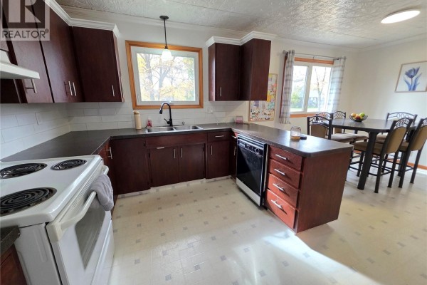 Kitchen and dining area with dark cabinets, a dining table, and chairs. - 503 Thompson Street, Herbert