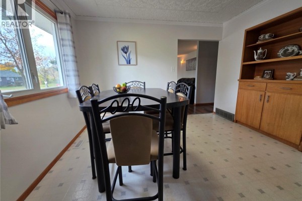 Dining area with a dark table, chairs, and a wooden hutch. - 503 Thompson Street, Herbert