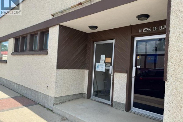 Entrance to the commercial building at 5033 50 Ave with glass doors and brown trim. - 5033 50ave, Ponoka