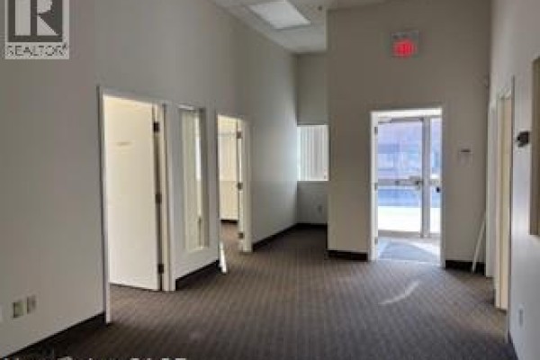 Interior hallway with multiple office doors and natural light from windows. - 5035 North Service Road Unit# C-13, Burlington