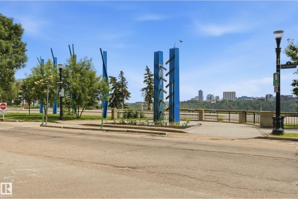 Park pathway with blue sculptures, trees, and a view of the city skyline in the distance. - #504 11710 100 Av Nw, Edmonton