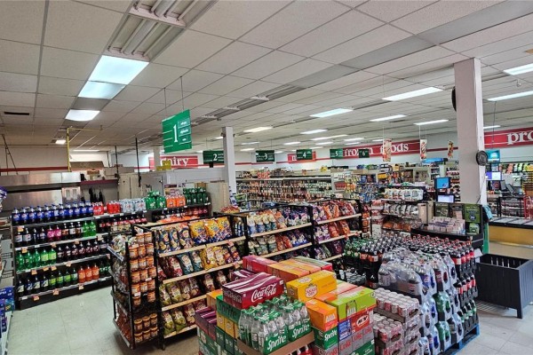Interior view of a grocery store showing aisles of chips, drinks, and other products. - 504 Front Street, Wolseley