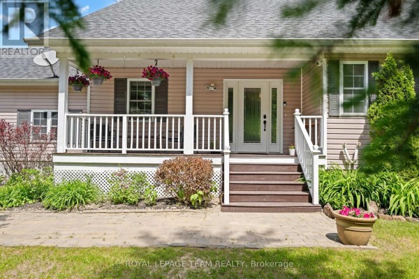 Laundry room with white cabinets, washer, dryer, and two doors. - 5040 Stonecrest Road, Ottawa