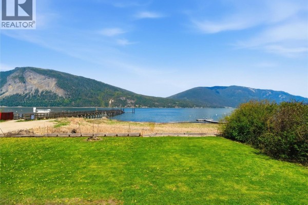 Aerial view of a long wooden pier with floating docks on a large blue lake. - 5041 75 Avenue Ne, Salmon Arm