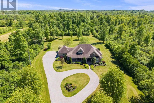Covered porch with wicker furniture and a brick exterior, featuring French doors. - 5045 Michener Road, Fort Erie