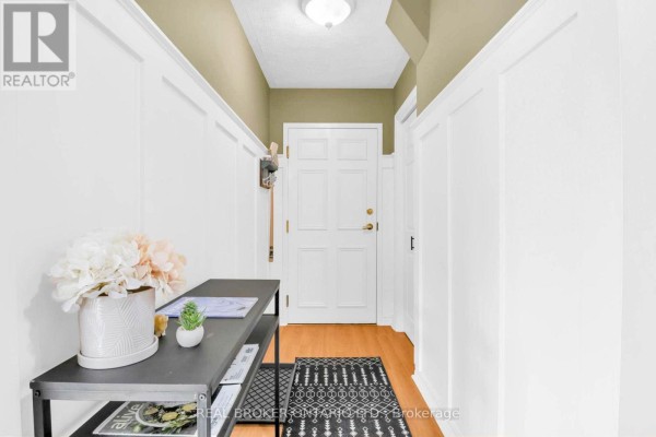 Interior entryway with white paneled walls, hardwood floors, and a white door. - 505 - 1717 2nd Avenue E, Owen Sound