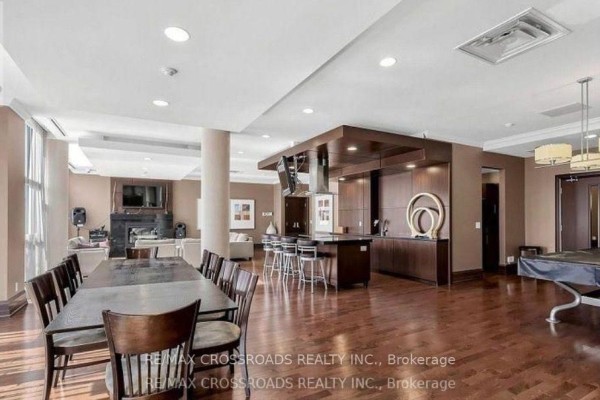 Communal living area with multiple sofas, a fireplace, entertainment system, and large windows. - 505 - 21 Upper Duke Crescent, Markham
