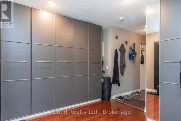 Hallway with grey built-in closet doors and dark wood floors. - 505 - 373 Front Street W, Toronto