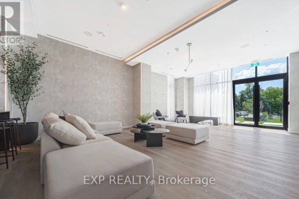 Spacious and bright communal lounge with modular sofas, coffee tables, and large windows. - 505 - 86 Dundas Street, Mississauga