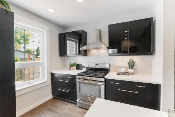 Close-up of a white kitchen island with a sink, bar stools, and place settings. - 505 Basswood Place, Winnipeg