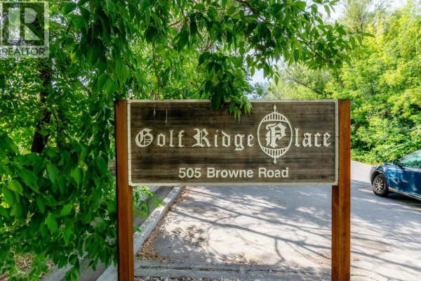 Wooden sign for 'Golf Ridge Place' at 505 Browne Road, surrounded by trees. - 505 Browne Road Unit# 210, Vernon