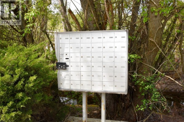 A wall of white mailboxes with individual locks on metal stands outdoors. - 505 Browne Road Unit# 210, Vernon