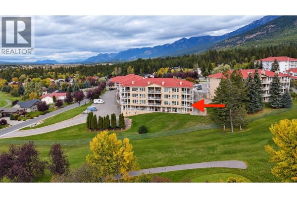 Aerial view of apartment building on a golf course with trees and mountains. - 5052 Riverview Road Unit# 2005 A, Fairmont Hot Springs