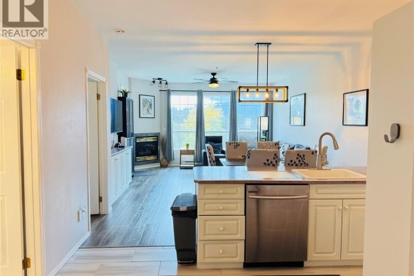 View of living area with fireplace and kitchen with island and dishwasher. - 5052 Riverview Road Unit# 2005 A, Fairmont Hot Springs