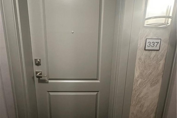 A grey apartment door with a silver handle, peephole, and the unit number 337 displayed. - 5055 Greenlane Street Unit# 337, Beamsville
