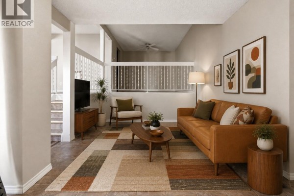 Living room with tile flooring, two chairs, a coffee table, and a sliding glass door with dark curtains. - 5056 10th Avenue, Regina