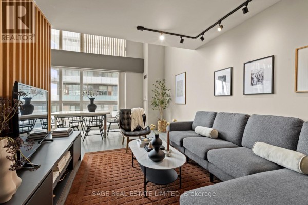 Balcony with a chair and sliding glass doors opening to an interior. - 506 - 18 Merton Street, Toronto