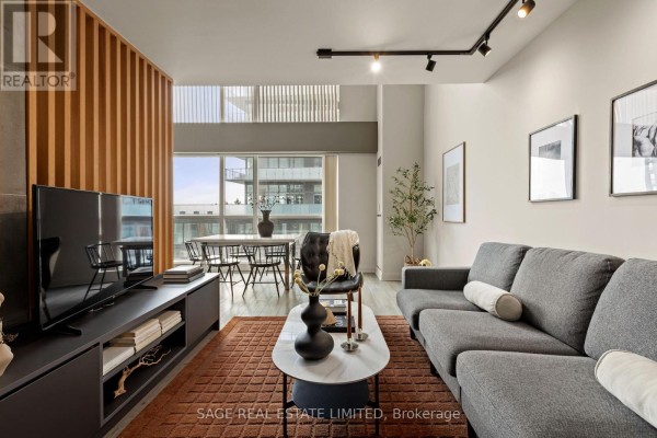 Living room with a sectional sofa, entertainment unit, dining area, and city view. - 506 - 18 Merton Street, Toronto