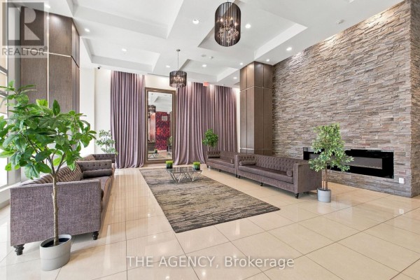Apartment building lobby with seating, stone accent wall, and fireplace. - 506 - 2756 Old Leslie Street, Toronto