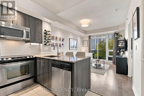 Kitchen and living room area with stainless steel appliances and city view. - 506 - 2756 Old Leslie Street, Toronto