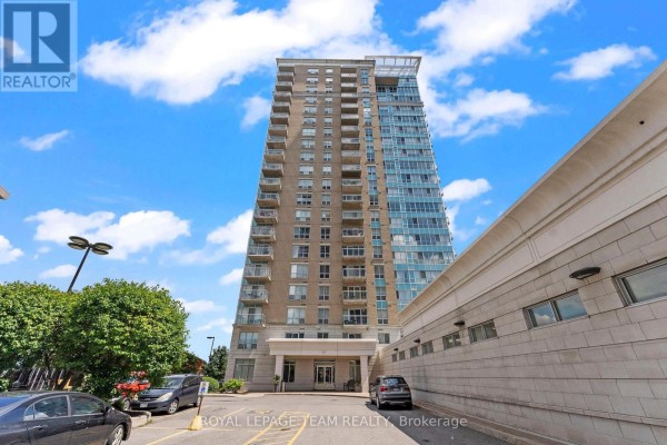 Front facade of a high-rise apartment building with an entrance canopy and parking. - 506 - 90 Landry Street, Ottawa