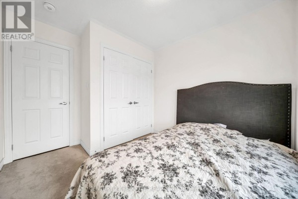 Bedroom with upholstered headboard and floral comforter - 506 Brooks Street Shelburne