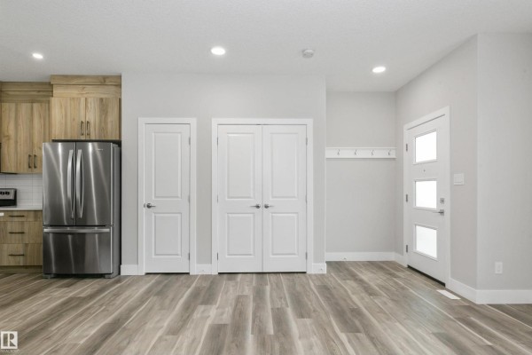 Entryway with dual closets, stainless steel refrigerator, and light wood cabinets. - 5060,5062,5064 Chappelle Rd Sw, Edmonton