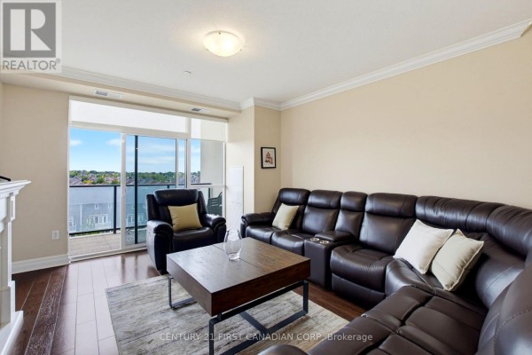 A living room with a leather sectional sofa, coffee table, and sliding glass doors to a balcony. - 507 - 260 Villagewalk Boulevard, London North