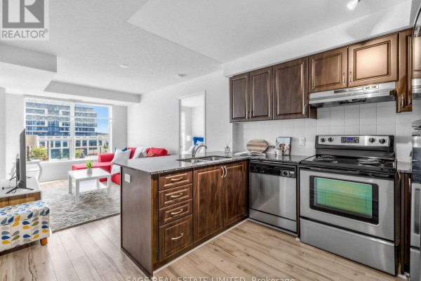 Modern kitchen with dark wood cabinets, granite counters, and stainless steel appliances. - 507 - 60 Fairfax Crescent, Toronto
