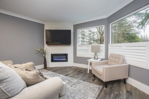 Bright corner living space featuring a TV, electric fireplace, and armchair - 507 1350 Vidal Street, White Rock