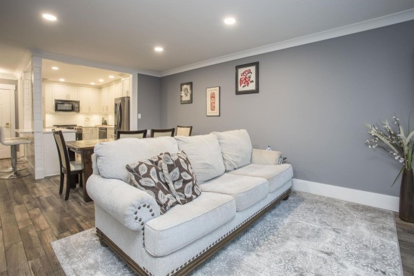 Open living area with a sofa, dining space, and view into the kitchen - 507 1350 Vidal Street, White Rock