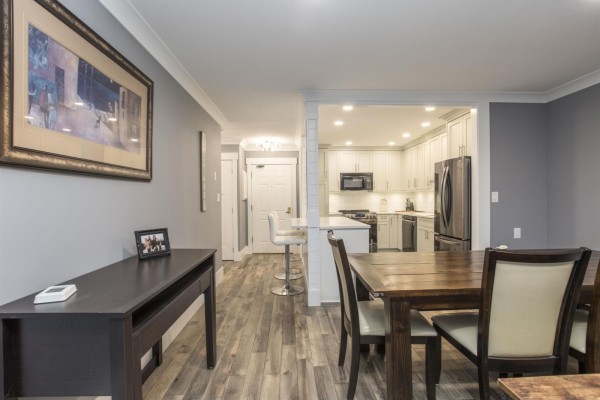 Dining area with wooden table, chairs, and view into the kitchen - 507 1350 Vidal Street, White Rock