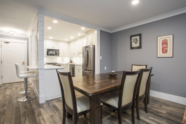 Modern kitchen with white cabinetry, stainless steel appliances, and bar seating - 507 1350 Vidal Street, White Rock